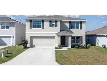 Inviting two-story home boasts a well-manicured lawn and a two-car garage at 8617 Triumph Cir, Wildwood, FL 34785