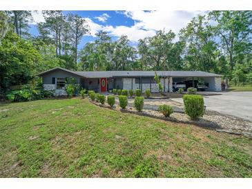 Charming single-story home with landscaped front yard, stone accents, and an inviting red front door at 4710 Se 30Th Ct, Ocala, FL 34480