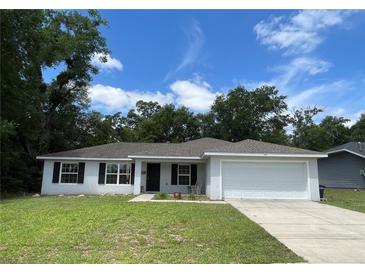 Charming single-story home with a well-manicured lawn and attached two car garage at 6306 Pecan Crse, Ocala, FL 34472