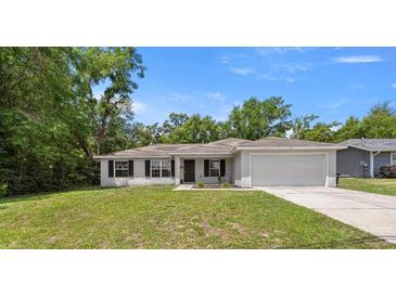 Charming single story home featuring a two car garage, manicured lawn, and classic curb appeal at 6306 Pecan Crse, Ocala, FL 34472