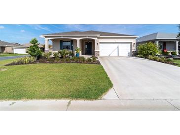 Charming single-story home featuring a well-maintained lawn, attractive landscaping, and an attached two-car garage at 7706 Sw 89Th Ct, Ocala, FL 34481