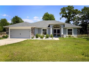 Charming single-story home with a well-manicured lawn and a two-car garage at 11609 Sw 59Th Ter, Ocala, FL 34476