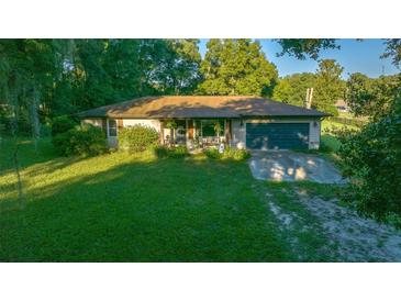 Charming ranch-style home features a lush green lawn and an attached two-car garage at 13232 Ne 39Th Ter, Anthony, FL 32617