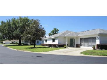 Charming single-story home featuring a screen garage, lush landscaping, and inviting curb appeal at 13618 Sw 111Th Cir, Dunnellon, FL 34432