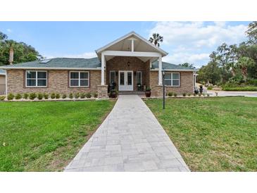 Charming single-story home featuring a stone facade, gabled entryway, and well-manicured front lawn at 170 Sw 80Th St, Ocala, FL 34476