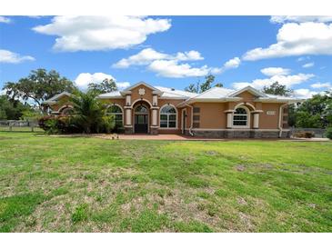 Charming single-story home featuring manicured lawn, neutral colors, and elegant arched windows at 3934 Se 110Th St, Belleview, FL 34420