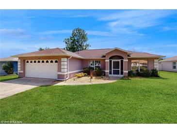 Charming home featuring a lush lawn, two-car garage, and inviting front entrance at 4757 Nw 45Th Ct, Ocala, FL 34482