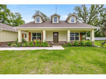 Charming home featuring dormer windows, a welcoming front porch, and a well-maintained lawn at 6600 Sw 109Th Ln, Ocala, FL 34476