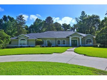 Charming single-story home with well-maintained lawn and lush landscaping creating a welcoming curb appeal at 7939 Se 12Th Cir, Ocala, FL 34480