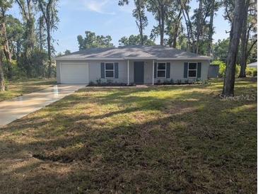 Charming single-story home with a well-maintained lawn and mature trees at 15 Juniper Trail Crse, Ocala, FL 34480