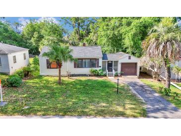 Charming home featuring a well-manicured lawn and a cozy, inviting facade, complemented by lush, mature trees at 426 Sw 13Th St, Ocala, FL 34471
