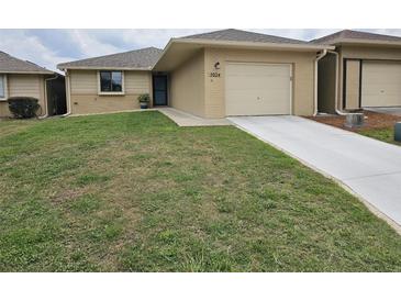 Charming single-story home with a well-manicured lawn and a one car garage at 5024 Se 107Th Pl, Belleview, FL 34420