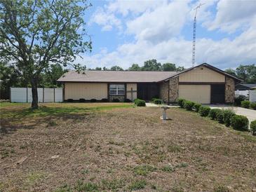 Charming single-story home featuring a well-kept lawn, stone accents, and an attached garage at 516 Marion Oaks Dr, Ocala, FL 34473