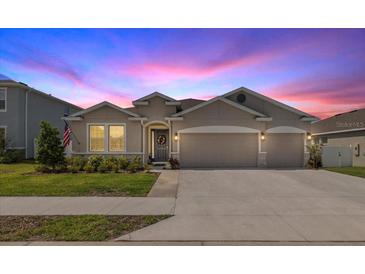 Charming single-story home with a well-manicured lawn and a two-car garage at dusk at 5862 Sw 80Th Ln, Ocala, FL 34476
