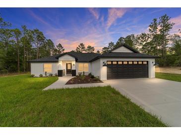 Charming single-story home boasts a two-car garage, landscaped yard, and a modern farmhouse design at 7483 Sw 121St Ter, Dunnellon, FL 34432