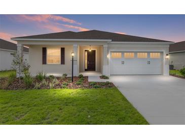 Charming single-story home with a well-manicured lawn, two car garage and inviting front entrance at 8783 Sw 69Th Place Rd, Ocala, FL 34481