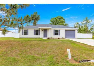 Charming single-story home with a well-maintained lawn, a grey roof and shutters, and a paved driveway at 97 Dogwood Cir, Ocala, FL 34472