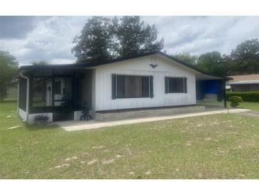 Charming single-story home with a screened porch and covered parking area, set on a well-maintained lawn at 9920 Sw 102Nd Pl, Ocala, FL 34481