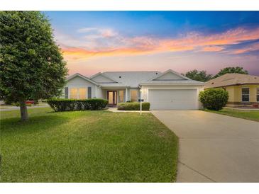 Charming single-Gathering home with manicured lawn, mature trees, and an attached two car garage at 1402 Arredondo Dr, The Villages, FL 32162