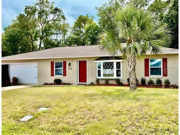 Charming home featuring a red door, red shutters, a bay window, and a well-manicured lawn at 3106 Silver Palm Dr, Edgewater, FL 32141