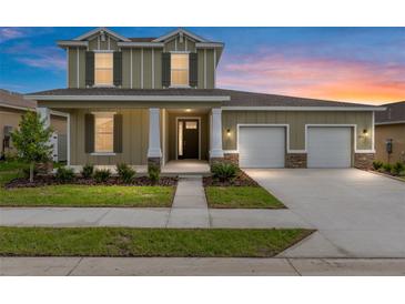 Two story home with a 2 car garage, front porch with columns and landscaping at 5894 Sw 77Th Ct, Ocala, FL 34481