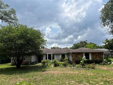 Charming single-story home with stone accents and mature landscaping in a well-maintained front yard at 9850 Sw 191St Ave, Dunnellon, FL 34432