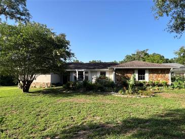 Charming single-story home with lush landscaping and a well-maintained lawn at 9850 Sw 191St Ave, Dunnellon, FL 34432
