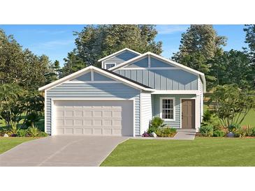 Charming single Gathering home with a two-car garage, light blue siding, a manicured lawn, and a paved driveway at 1139 Nw 44Th Court Rd, Ocala, FL 34482