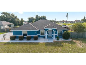 Overhead shot of a charming blue single-story home with a well-kept lawn and landscaped front yard at 13115 Sw 49Th Ave, Ocala, FL 34473