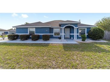 Charming blue single-story home with manicured landscaping, decorative rock, and an inviting entrance at 13115 Sw 49Th Ave, Ocala, FL 34473