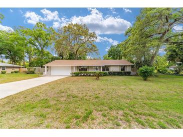 Charming single-story home with a well-manicured lawn and mature trees at 2220 Ne 41St St, Ocala, FL 34479