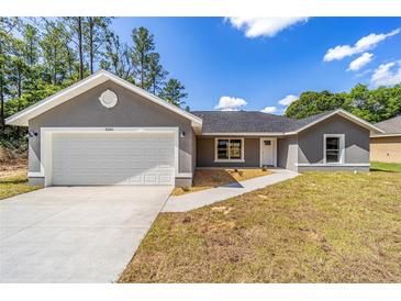 Charming single-story home featuring a neutral exterior and a two-car garage at 6689 Nw 61St St, Ocala, FL 34482