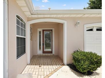 Charming front entrance with decorative glass door, brick paving, and arched entryway at 8617 Se 141St Street Rd, Summerfield, FL 34491