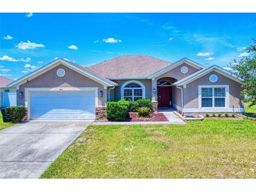 Charming single-story home with a well-manicured lawn and an attached two-car garage at 9677 Sw 56Th Cir, Ocala, FL 34476