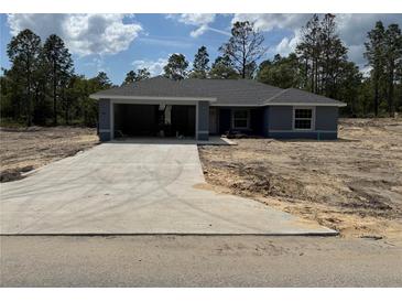New construction single-story home featuring an attached two-car garage and a concrete driveway at 15419 Sw 65Th Terrace Rd, Ocala, FL 34473