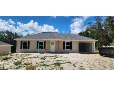 Charming single-story home featuring a welcoming front porch and an attached open garage at 24146 Sw South Lakes Ct, Dunnellon, FL 34431