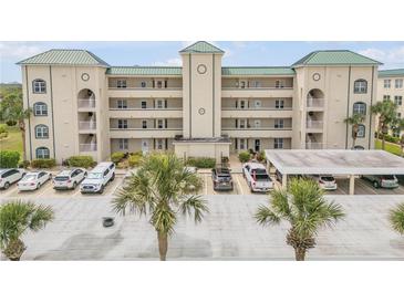 Condo building exterior with lush palm trees and convenient parking spaces at 420 Bouchelle Dr # 204, New Smyrna Beach, FL 32169