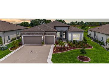Beautiful home featuring a stone facade, a well-manicured lawn, and a two-car garage at 8606 Sw 61St Loop, Ocala, FL 34481