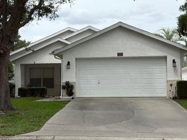 Charming single-story home featuring a two-car garage, well-maintained lawn, and classic landscaping at 9285 Sw 92Nd Place Rd, Ocala, FL 34481