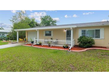 Charming single-story home featuring a manicured lawn and a quaint, fenced-in front porch area at 9940 Sw 101St Pl, Ocala, FL 34481