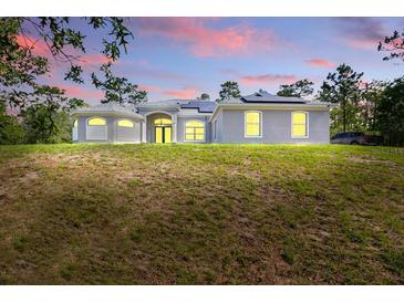 Charming single-story home featuring well-manicured lawn, arched windows, and a welcoming entrance at 22189 Sw Neptune Blvd, Dunnellon, FL 34431