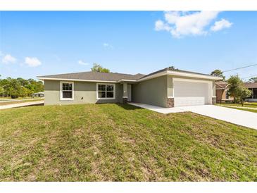 Charming single-story home featuring a well-manicured lawn and attached two-car garage at 25 Juniper Pass Way, Ocala, FL 34480