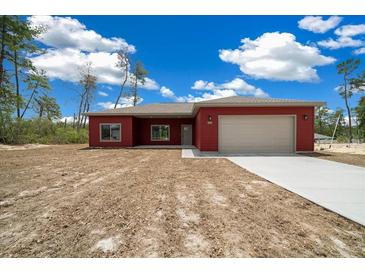 Charming one-story home with a two-car garage, red siding, and a well-manicured lawn at 4312 Sw 172Nd Place Rd, Ocala, FL 34473