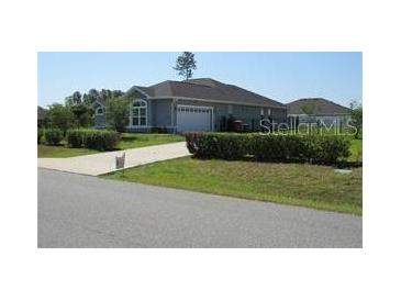 Charming single-story home featuring a well-maintained lawn and a long private driveway leading to an attached garage at 4770 Sw 114Th St, Ocala, FL 34476