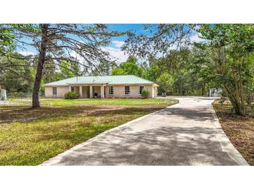 Charming single-story brick home featuring a long driveway and a large, wooded lot at 505 Fisher Rd, Ocklawaha, FL 32179