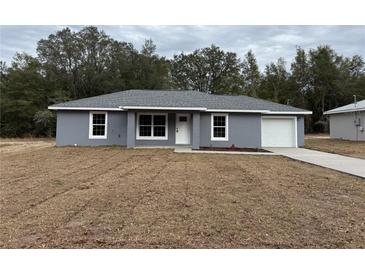 Charming single-story home with gray exterior, white trim, and a well-manicured lawn at 5323 Nw 8Th Pl, Ocala, FL 34482