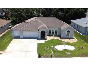 Well maintained single-story home featuring a three-car garage, landscaped yard, and manicured lawn at 5340 Nw 26Th Ln, Ocala, FL 34482