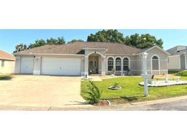 Charming single-story home featuring a well-manicured lawn and a spacious two-car garage at 5340 Nw 26Th Ln, Ocala, FL 34482