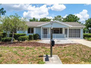 Charming single-story home with a well-maintained yard and covered front porch at 8463 Sw 108Th Pl, Ocala, FL 34481