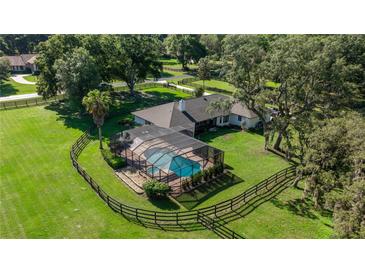 Aerial view of the property with a screened pool, fenced yard, and mature landscaping at 9462 Sw 72Nd Ct, Ocala, FL 34476